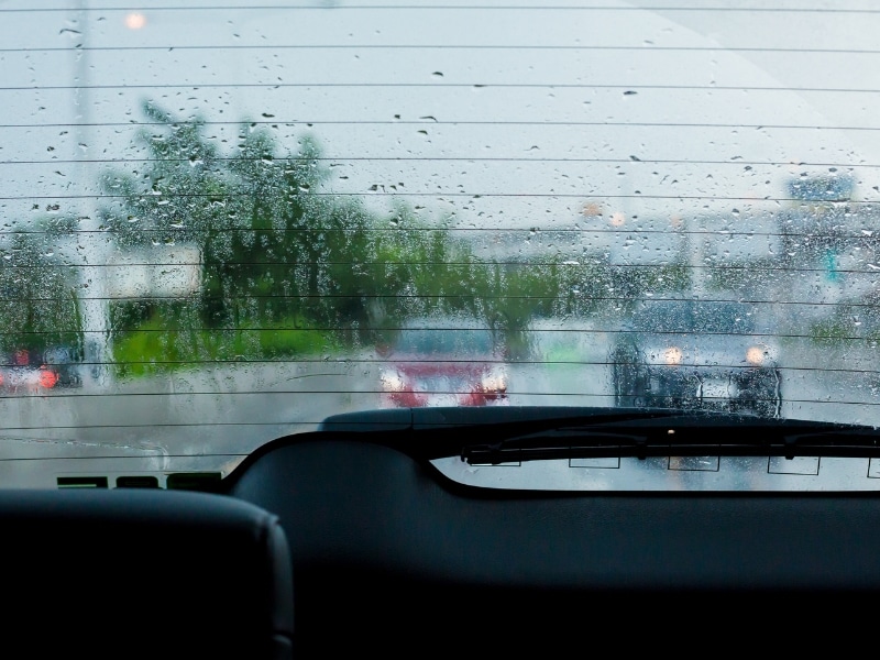 Broken rear windscreen with water streaks reducing visibility in wet weather