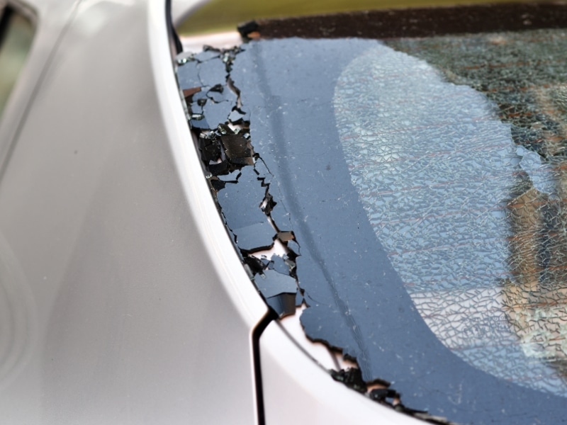 Broken rear windscreen with deep cracks and peeling safety film