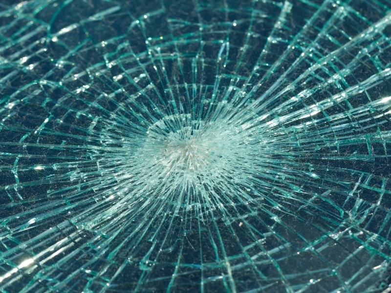 Detailed view of impact pattern on smashed rear windscreen with radiating cracks